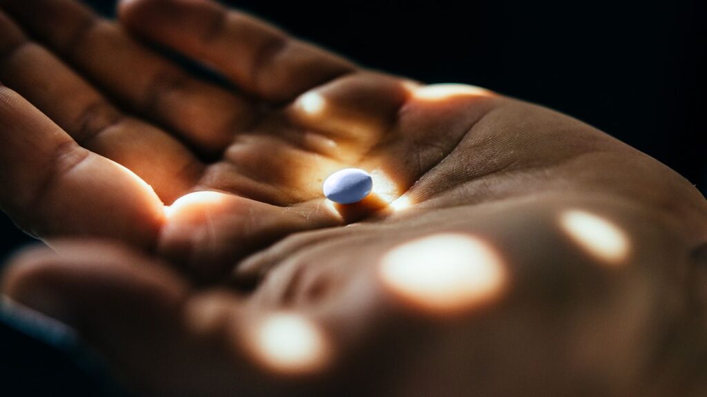 Closeup of blue pill in palmx